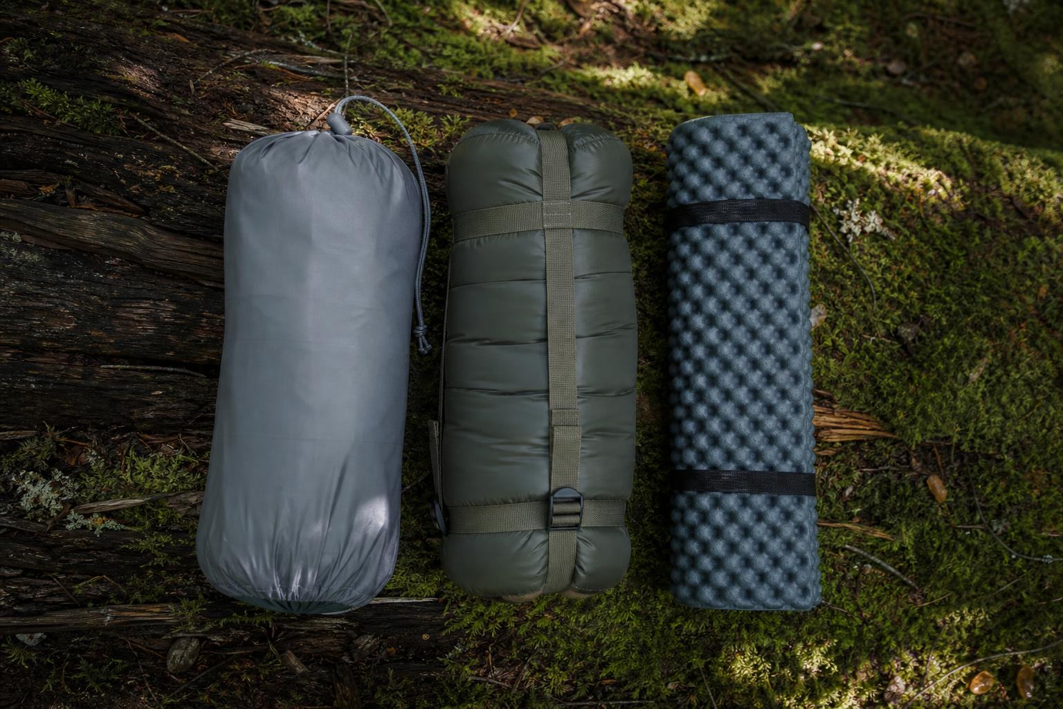 Trio de nuit trekking tente sac de couchage matelas flatlay forêt