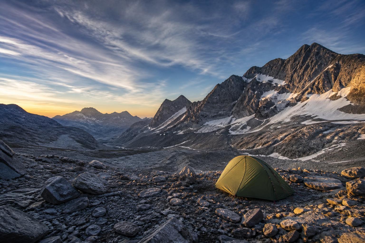 Tente de trekking légère installée en bivouac sur un col alpin à 2500 mètres