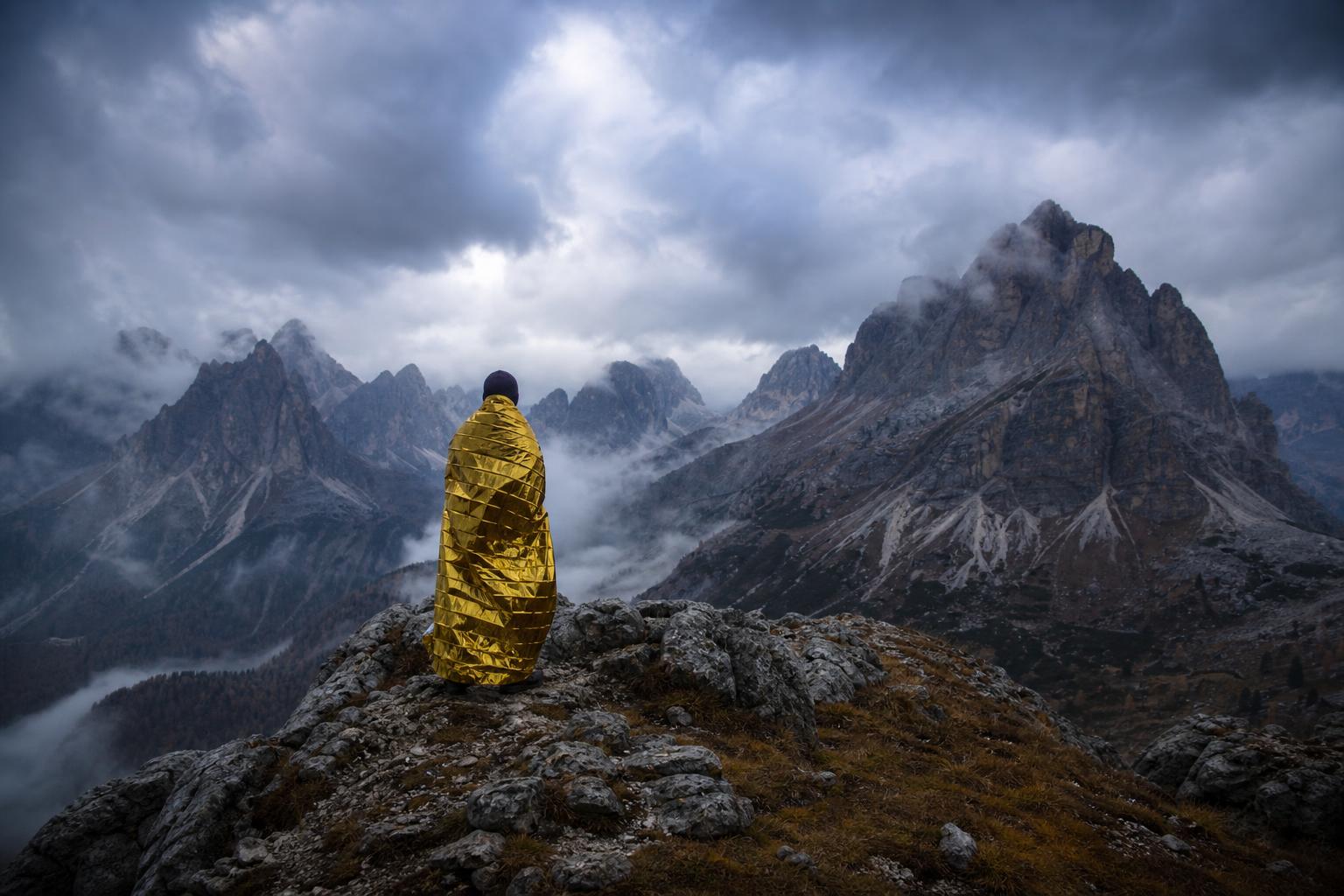 Couverture de survie dorée déployée en montagne lors d'une randonnée