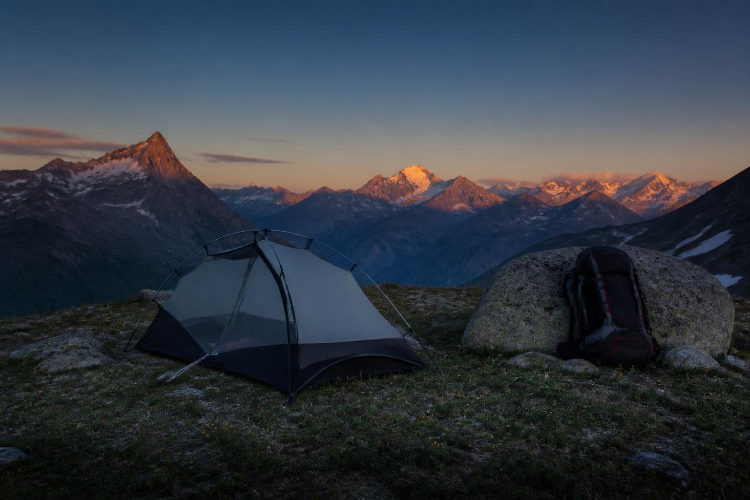 Installation tente bivouac légale haute montagne crépuscule sac à dos randonneur