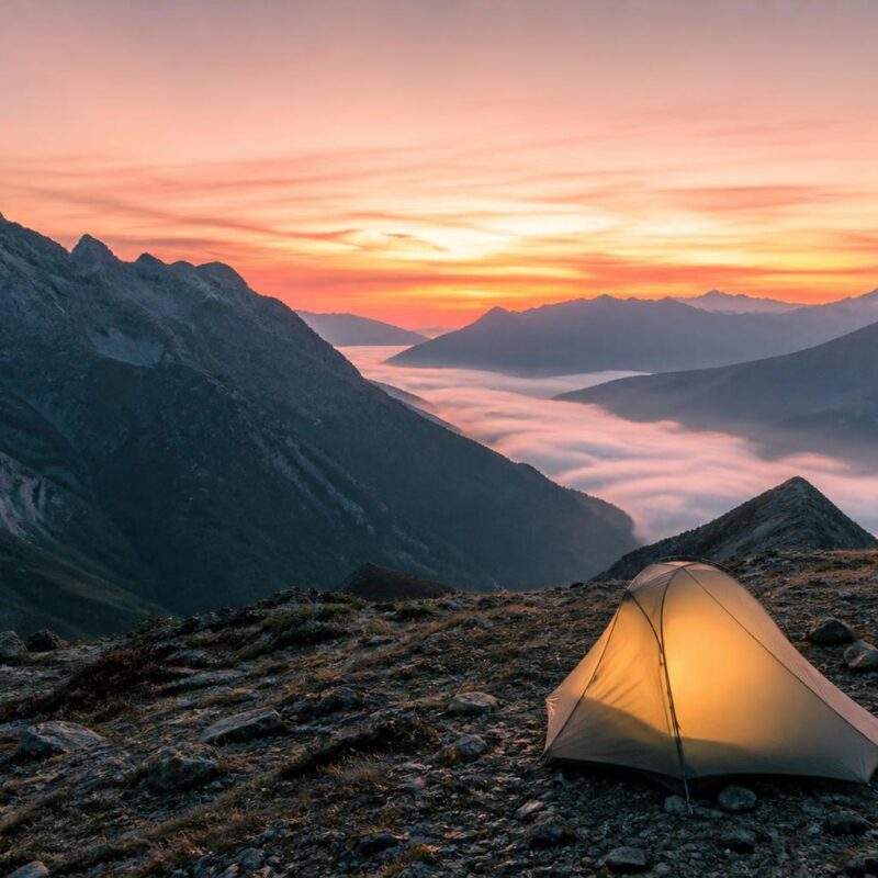 Tente de bivouac légère au lever du soleil en haute montagne France