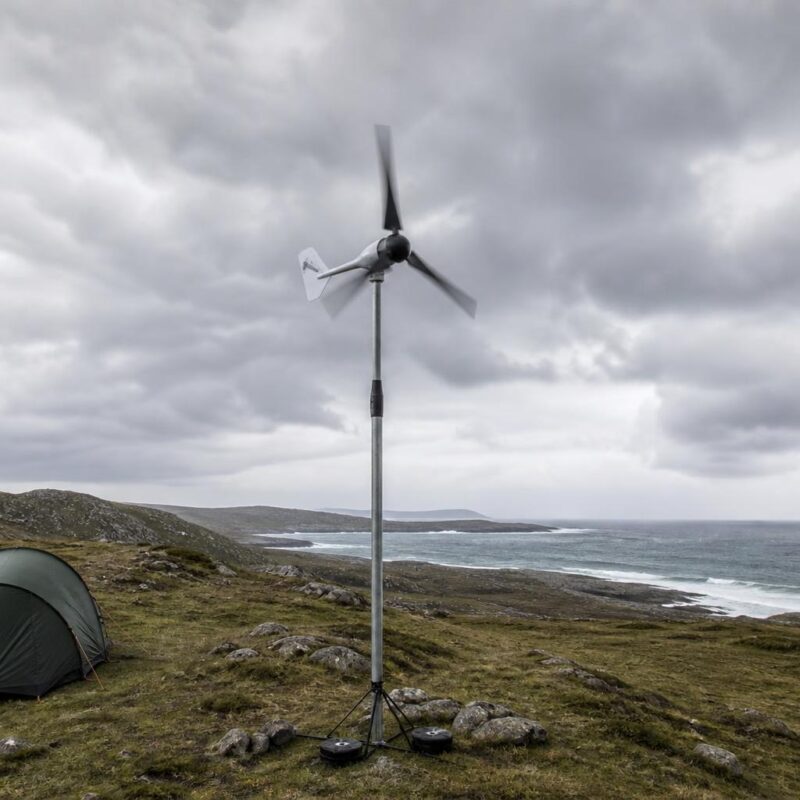 Éolienne portable sur mât dans un campement côtier venteux par temps nuageux