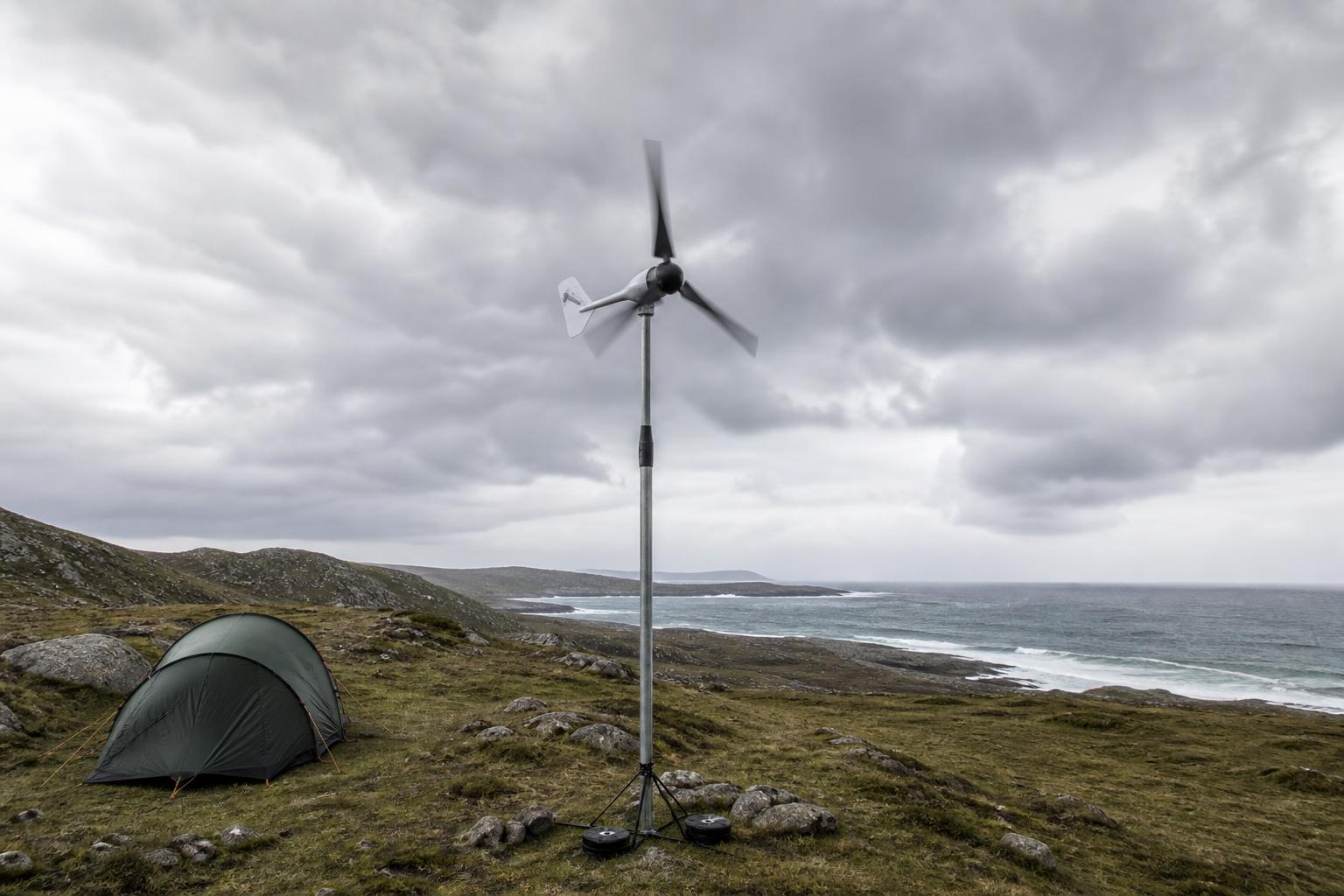 Éolienne portable sur mât dans un campement côtier venteux par temps nuageux