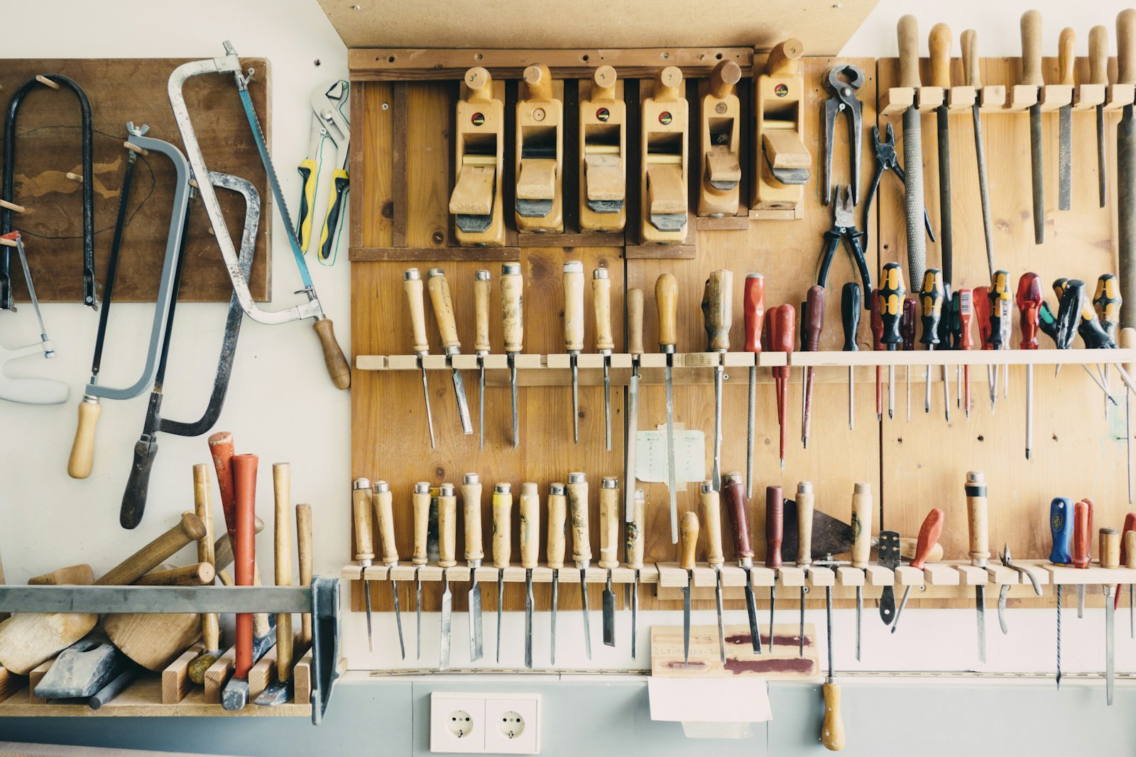 Panneau mural d'outils à main dans un atelier : scies, ciseaux à bois, tournevis