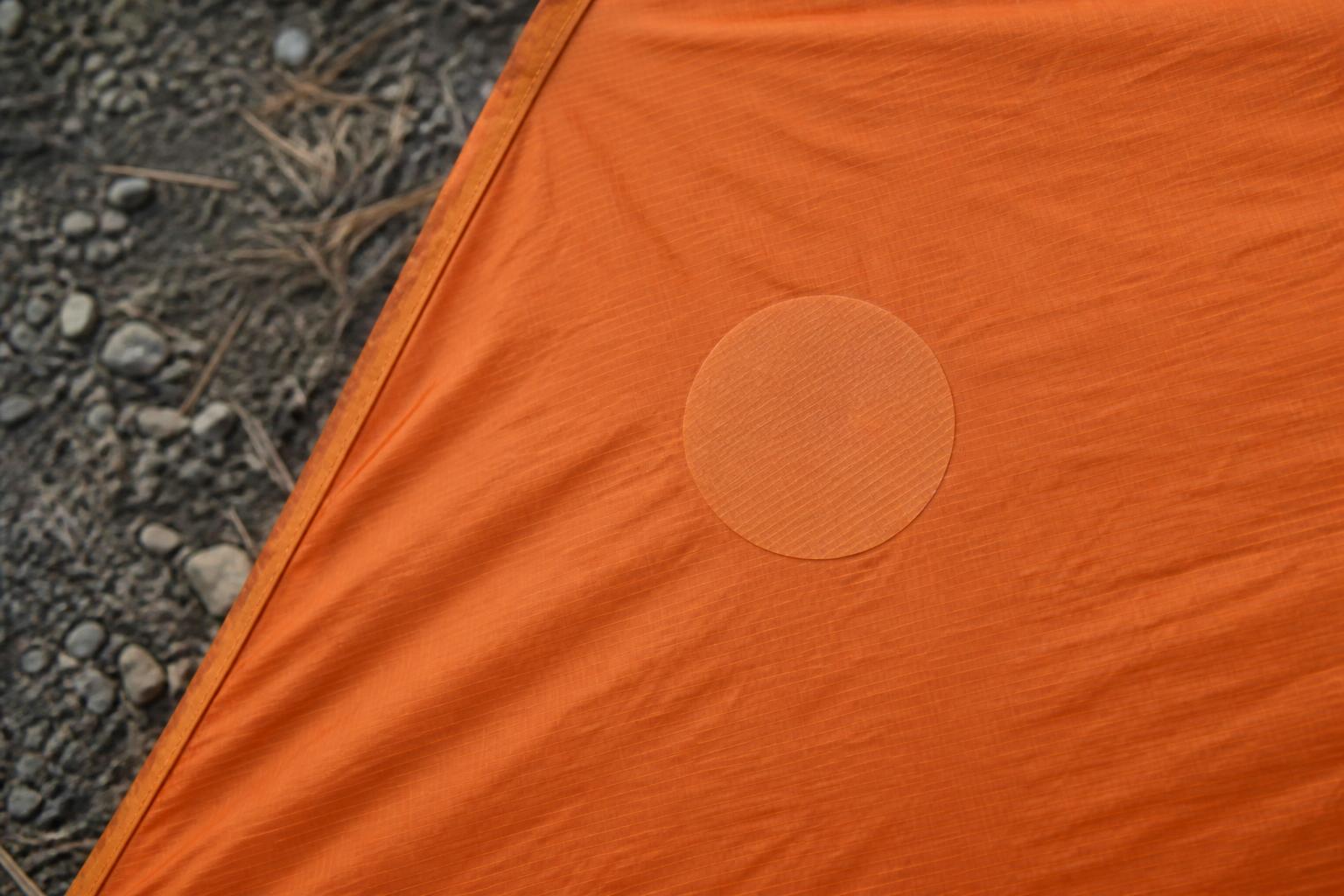 Rustine autocollante bien appliquée sur toile nylon de tente, sans bulles